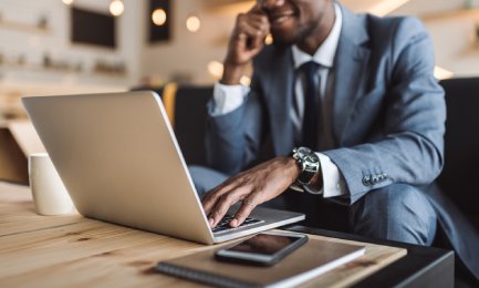 selective focus of handsome african american businessman using laptop in cafe