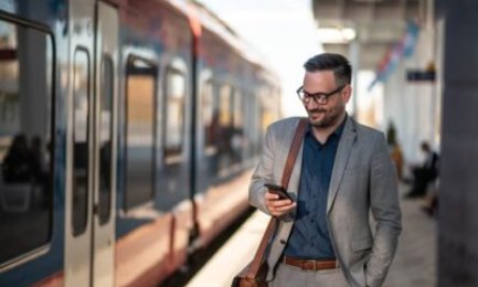 Businessman using mobile phone at train station